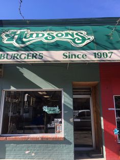 the outside of a restaurant with green and white awning