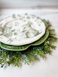 three plates with green designs on them sitting on a table