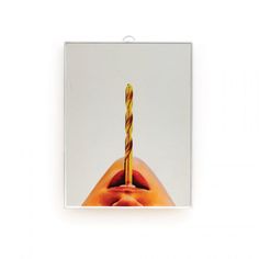 an apple with a candle sticking out of it's core, in front of a white background