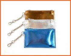 three different colored purses with chains hanging from them