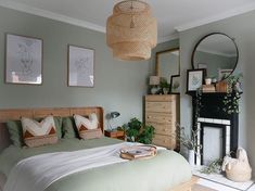 a bed room with a neatly made bed next to a fire place and pictures on the wall