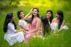 four beautiful young women sitting in the grass