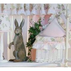 a statue of a rabbit sitting next to a baby crib