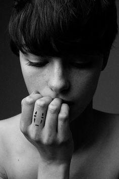 black and white photograph of a person holding their hand to her face with the word love written on it