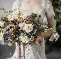 a woman holding a bouquet of flowers in her hands