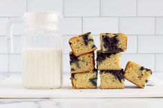 blueberry muffins stacked on top of each other next to a bottle of milk