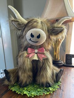 a stuffed animal sitting on top of a wooden table next to a lamp and other items