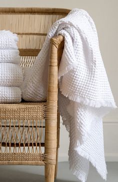 a wicker chair with white towels on it