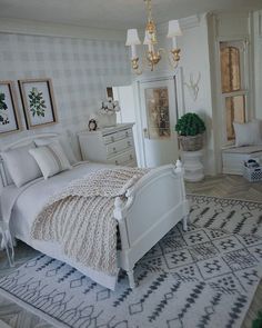 a white bed sitting in a bedroom on top of a rug