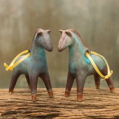 two small ceramic horses with yellow ribbons on their necks are standing next to each other