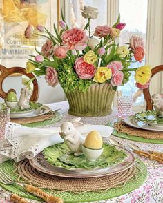 an easter table setting with flowers in a basket