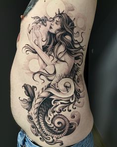 a woman's stomach with an intricate tattoo design on the side and her belly