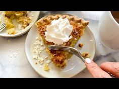 a piece of pie on a white plate with whipped cream and a fork in it