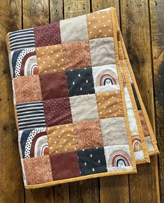 two quilted placemats sitting on top of a wooden table next to each other