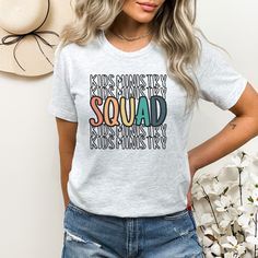 a woman wearing a t - shirt with the words squad on it in multicolored letters