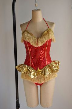 a mannequin wearing a red and gold costume with fringes on it's sides