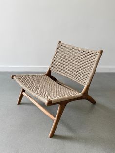 a chair made out of wicker sitting on top of a gray carpeted floor