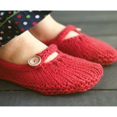 a woman's feet wearing red slippers with buttons