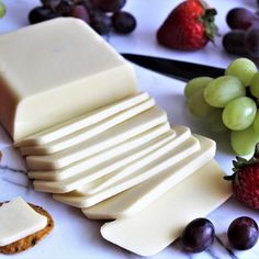 sliced cheese, grapes and crackers on a table