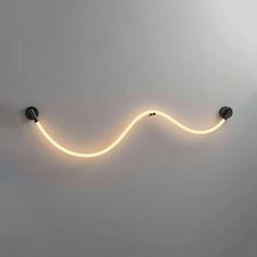 a wall mounted light with a long cord on it's side and two lights above it