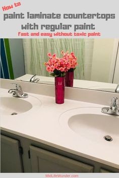 a bathroom vanity with two sinks and a vase full of flowers on the counter top