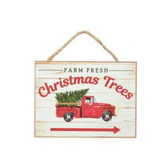 a red truck with a christmas tree in the bed is hanging on a sign that says farm fresh