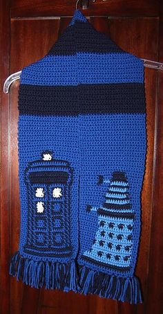 a crocheted scarf hanging on a door with a knitted doctor who is next to it