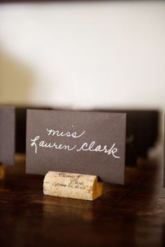 some wine corks sitting on top of a table next to a sign that says, mess lauren clark