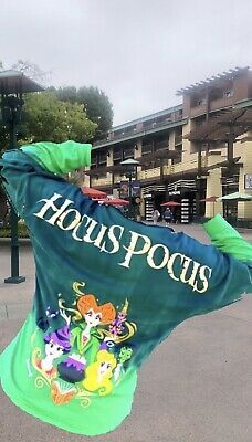 a person is holding up a large green flag in the middle of a parking lot