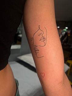 a woman's arm with a line drawing of a face and heart on it