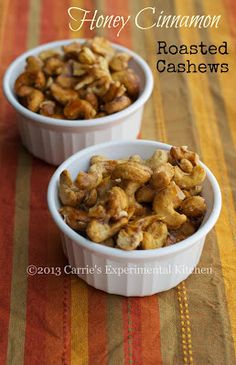 two white bowls filled with nuts on top of a table