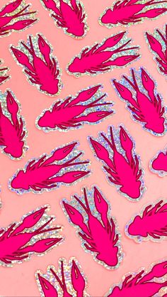 pink and silver stickers on a pink background with lots of small red feathers in the middle