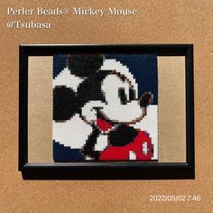 a cross - stitch picture of mickey mouse is hanging on a cork board with the words perler beads & mickey mouse