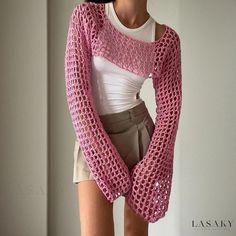 a woman is wearing a pink crocheted sweater