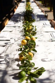 a long table is set with glasses and plates