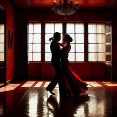 a man and woman are dancing in an empty room with chandelier hanging from the ceiling