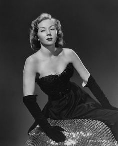 a black and white photo of a woman in a dress with sequins on the skirt