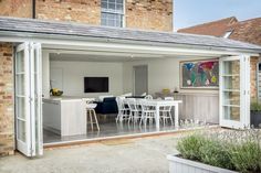 an outdoor kitchen and dining area with sliding glass doors leading to the back patio,