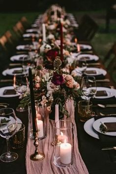 a long table with candles and plates on it