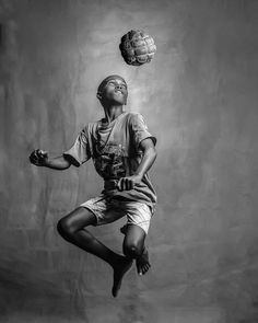 a black and white photo of a person jumping in the air to catch a ball