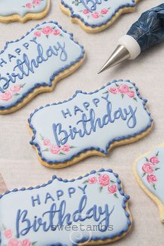 decorated cookies with happy birthday written on them next to a pen and paper clipping