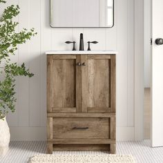 a bathroom with a sink, mirror and wooden cabinet in it's center area