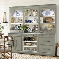 a gray china cabinet with plates and bowls on it