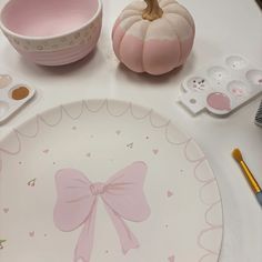 a white table topped with pink plates and other decorating items on top of it