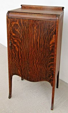 an old wooden cabinet sitting on top of a white carpeted floor next to a wall