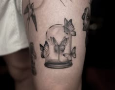 a person with a tattoo on their leg that has birds flying around it and a glass dome in the middle