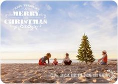 three people sitting on the beach with a christmas tree in front of them and an image of a merry christmas