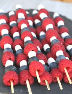 there are many raspberries and marshmallows on the skewers