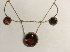 "A late victorian or Edwardian(circa 1890-1915), 18k(750 stamped on spring ring), yellow gold large fancy bezel set Madera Citrines and natural pearl necklace.  Condition-no problems, bright yellow gold all seed pearls in gallery framing citrines are present and lustrous.  Delicate floral , pearl stations from which the chain swags. The center citrine is 21mm(central pendant is 26mm, two smaller citrines are 12mm.  Lenght  16\", wt. 20.4 grams.  Best deep golden/hint or orange color.  Finest qua Evening Yellow Gold Cabochon Jewelry, Victorian Yellow Gold Cabochon Jewelry, Antique Round Jewelry With High Luster, Antique Round High Luster Jewelry, Antique High Luster Round Jewelry, Antique Round Necklace With Rose Cut Diamonds, Formal Amber Necklace In Fine Jewelry Style, Victorian Gold Faceted Jewelry, Victorian Round Faceted Jewelry