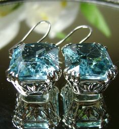 Simulated Aquamarine Earrings LUV Design#E29 Custom Made These are lovely Art Nouveau Inspired sterling silver filigree earrings. The silver of these earrings has a gorgeous Antique patina to it. These 26ctw flawless blue rectangle-cushion-cut man-made/simulated blue aquamarine gems are 18mm (just over 3/4th of an inch) by 13mm (1/2 inch) in size each. The earrings are 1 3/8th inches long. Notice the beautiful swirl floral filigree of the settings. This is a well made beautiful pair of sterling Elegant Blue Diamond Cut Earrings, Blue Sterling Silver Diamond Cut Earrings, Blue Sterling Silver Earrings With Diamond Cut, Blue Sterling Silver Earrings For Evening, Dazzling Blue Earrings For Gift, Exquisite Blue Earrings For Evening, Exquisite Hallmarked Blue Earrings, Exquisite Blue Hallmarked Earrings, Mystic Fire Topaz